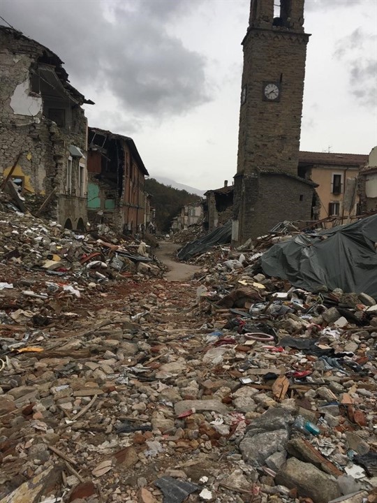 Photo 12: Destruction of buildings in the center of Amtrich. The clock tower survives despite being built from the same materials because of a higher cycle time, and different from the dominant time of the quake. Nylons cover some of the wreckage to protect equipment that has not yet been collected, 10/26/16. Photo: Yaron Ofir